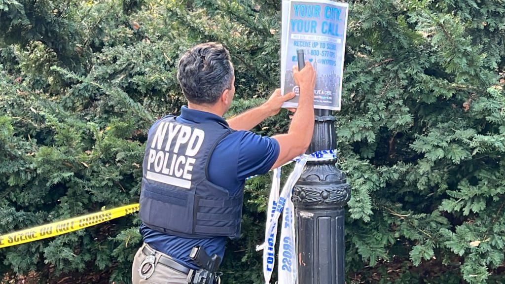 Detective puts up Crime Stoppers posters in Central Park after the attack/Upper East Site