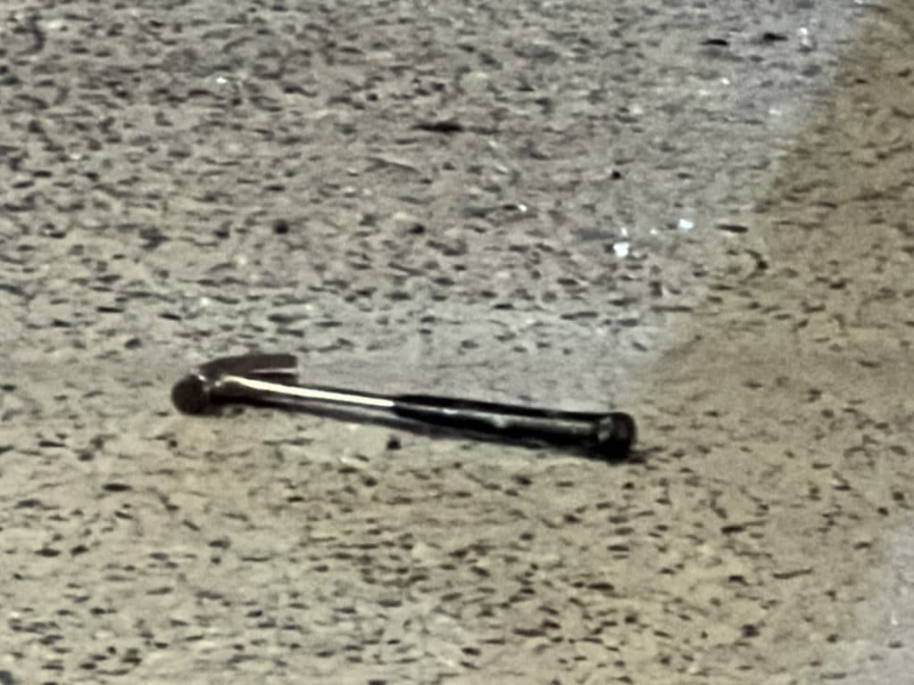 Hammer lays on sidewalk near smashed entrance to Givenchy/Upper East Site