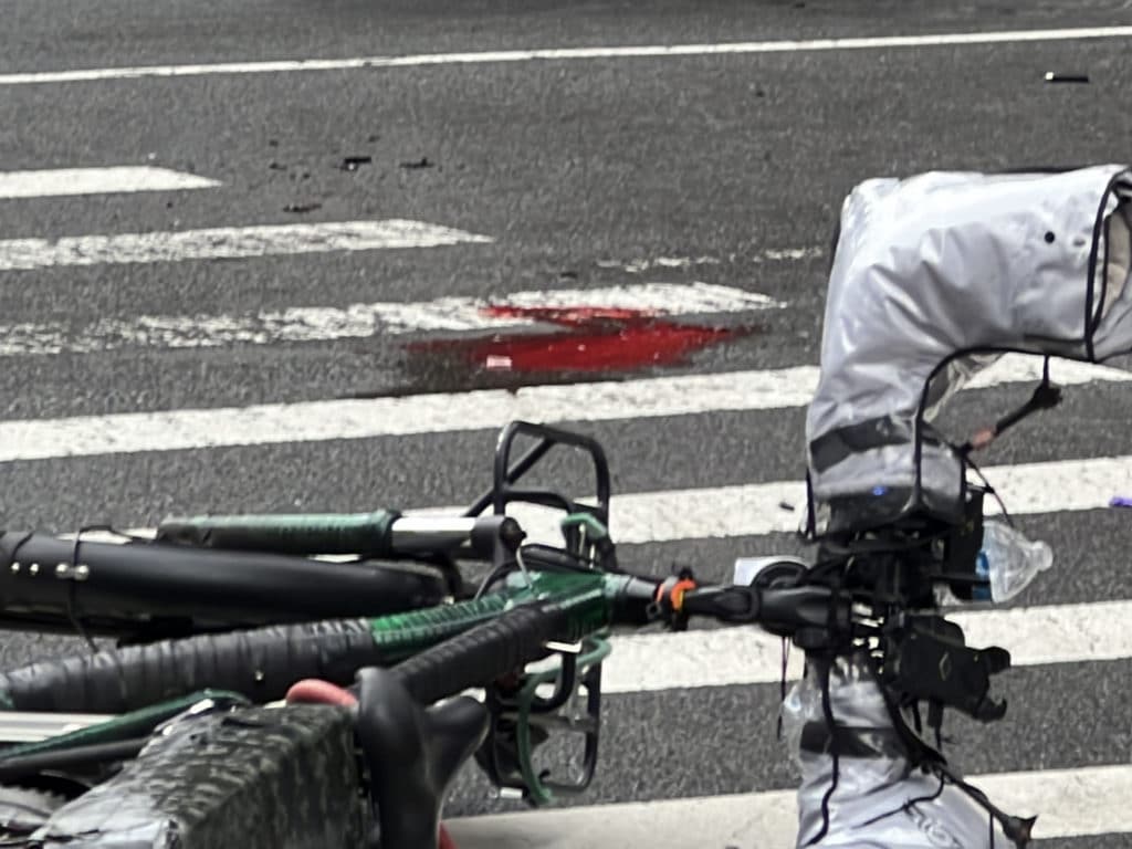 A small puddle of blood on the pavement where the cyclists were treated by first responders/Upper East Site