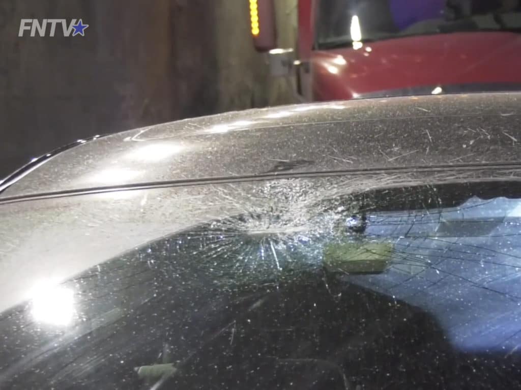 Car's windshield smashed by debris from tractor trailer collision with overpass