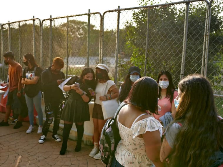 Students line up outside of a high school in Queens. Students across the city will no longer be required to wear masks outdoors on school grounds/Gabby Jones for Chalkbeat