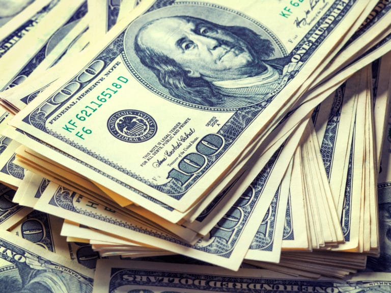 Photo shows stacks of hundred dollar bills.