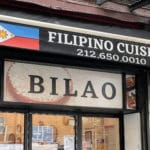 Photo shows to top of a restaurant storefront with signage reading 'Filipino Cuisine' and featuring the Filipino flag. The name 'Bilao' is written below.