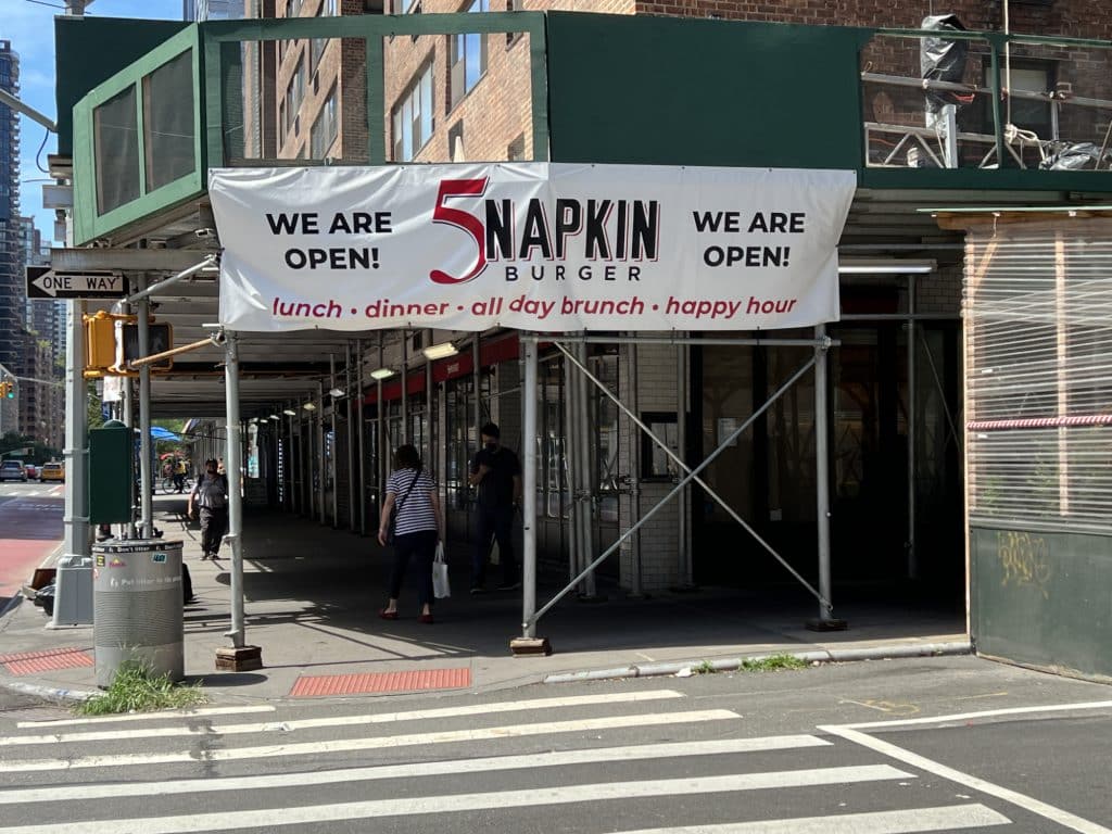 'WE ARE OPEN!' banner hangs above closed restaurant | Upper East Site
