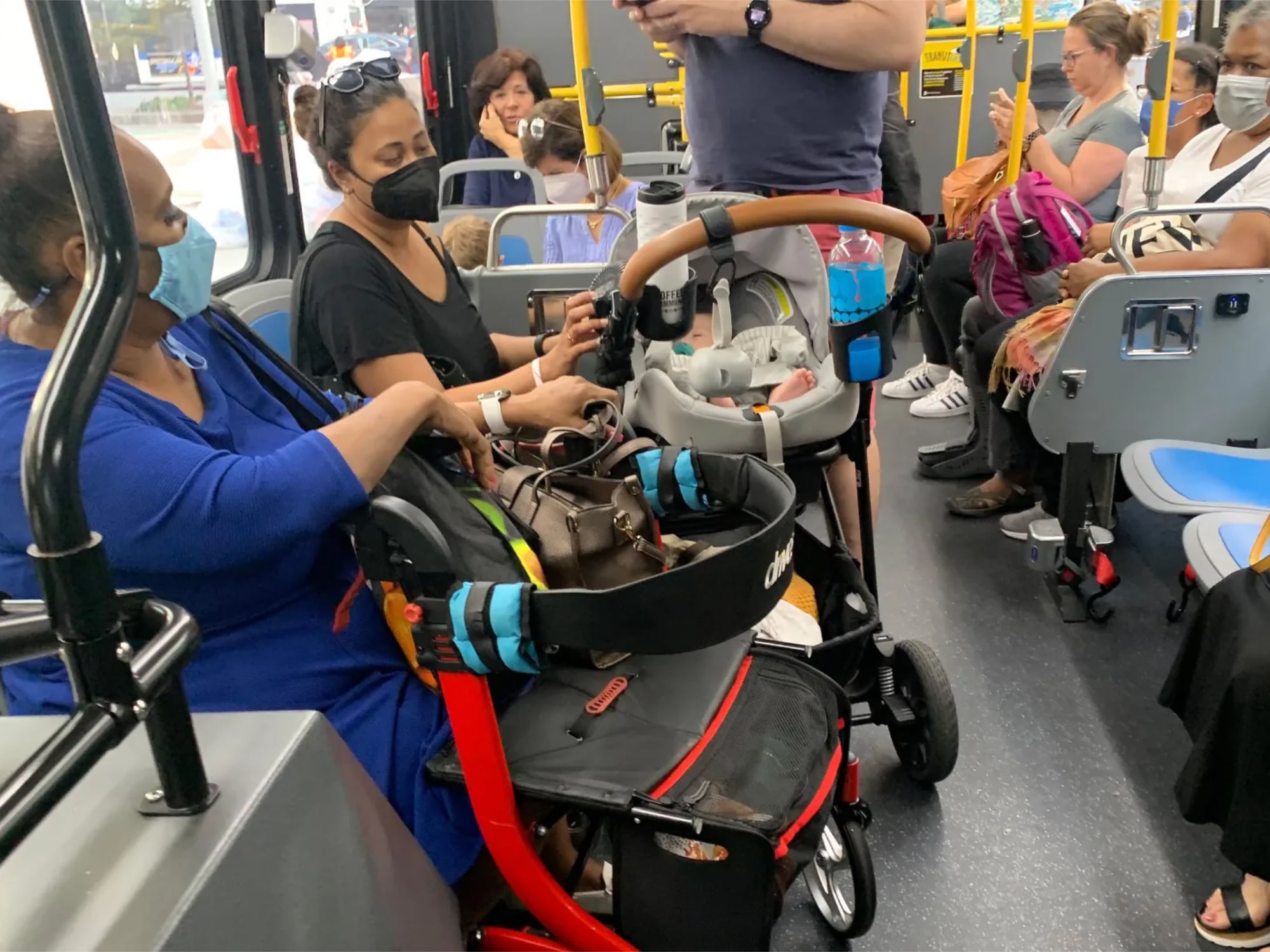 A stroller and a walker share space in the “wheelchair priority seating” at the front of a westbound M72 bus in Manhattan