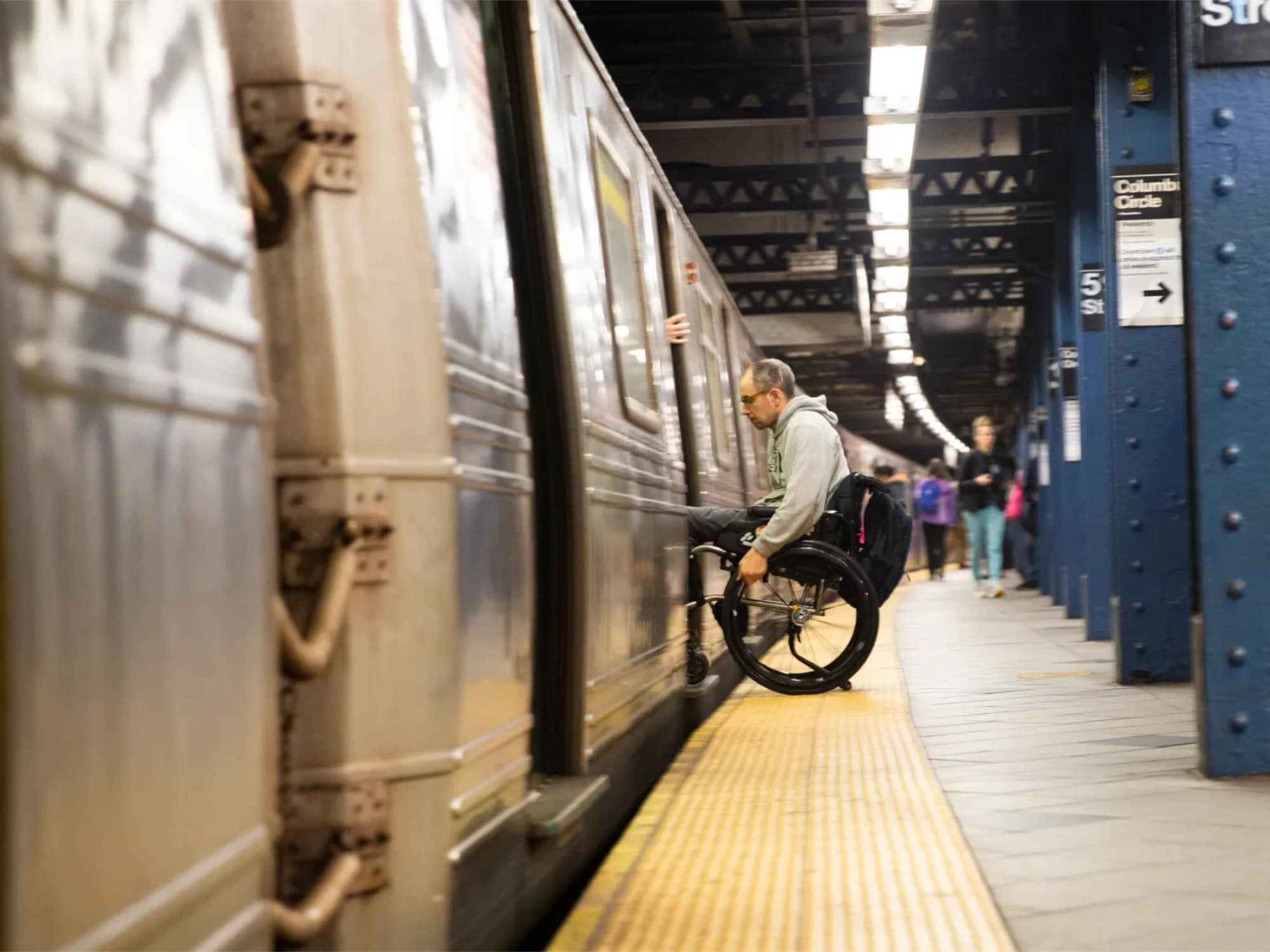 Disability-rights advocate Sasha Blair-Goldensohn navigates a platform gap at the Columbus Circle subway station