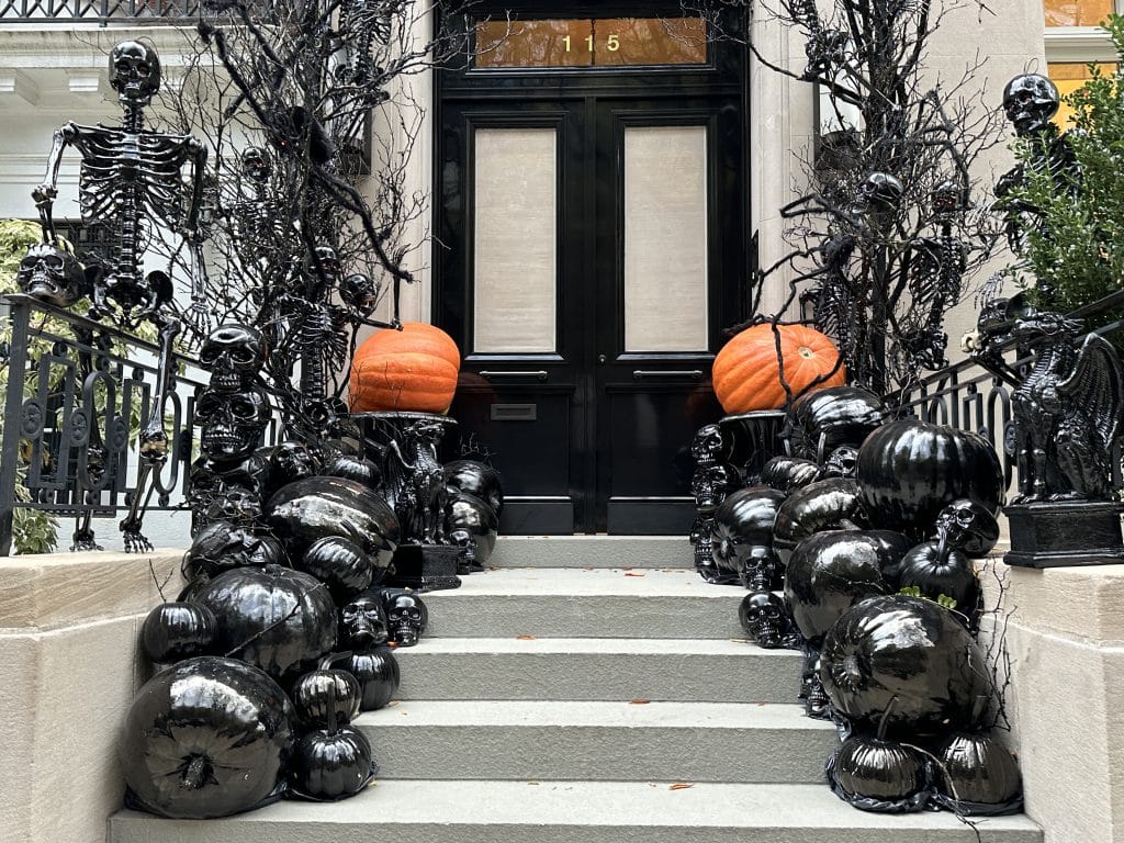 Glossy black skeletons with red eyes line the stoop at 115 East 70th Street | Upper East Site