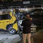 Taxi driver looks at wrecked cab destroyed by speeding Cadillac on the Upper East Side