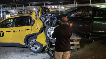 Taxi driver looks at wrecked cab destroyed by speeding Cadillac on the Upper East Side