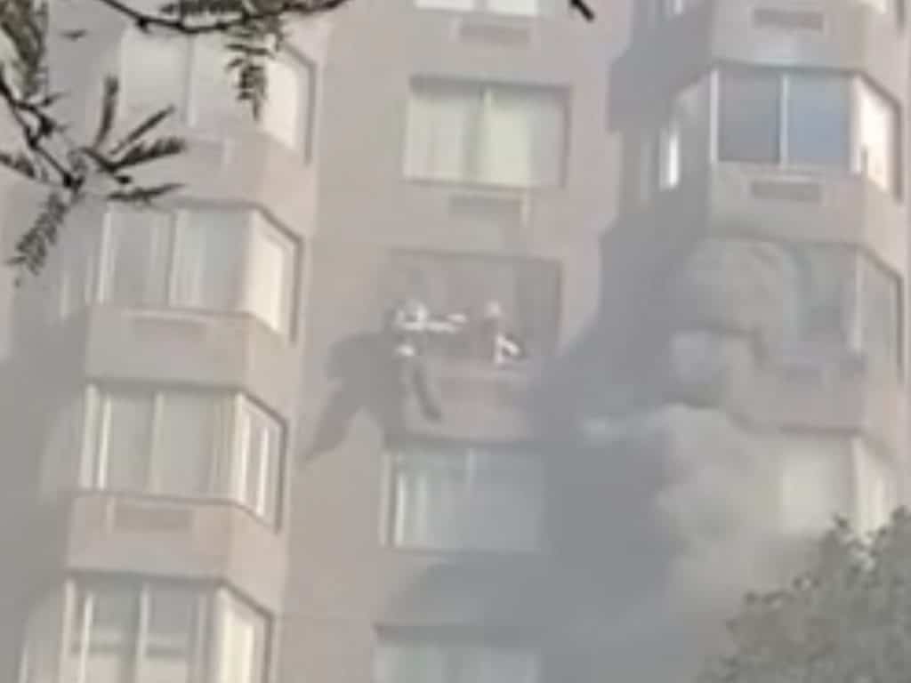 The two residents hanging from the window can be seen reaching out to each other 