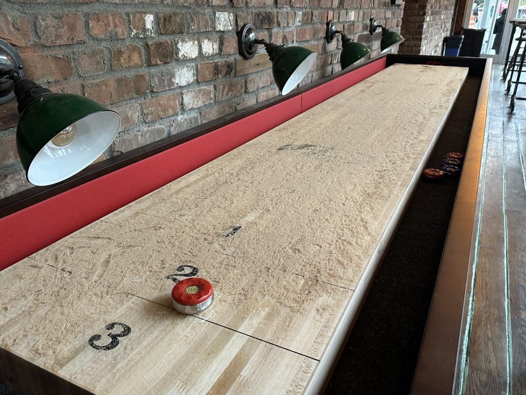Free shuffleboard is available in the back of Plug Uglies | Upper East Site