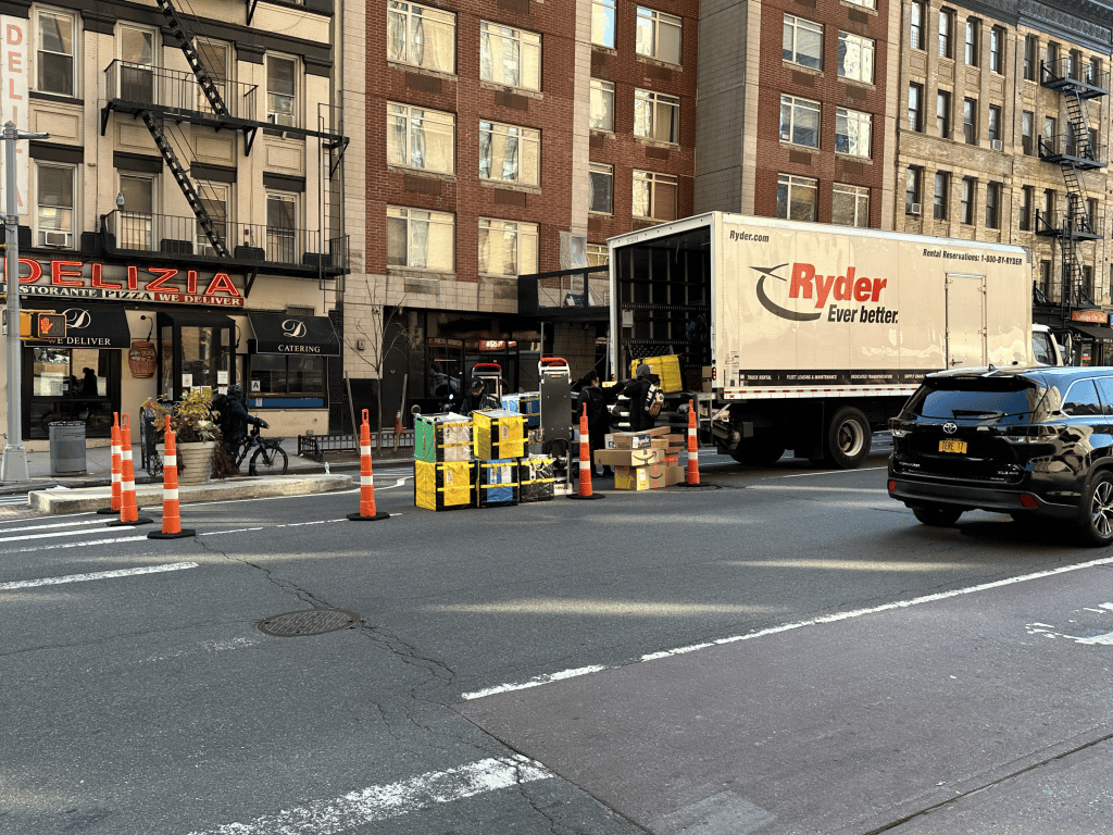 Amazon workers sort packages in traffic double parked next to open spaces on Second Avenue | Upper East Site