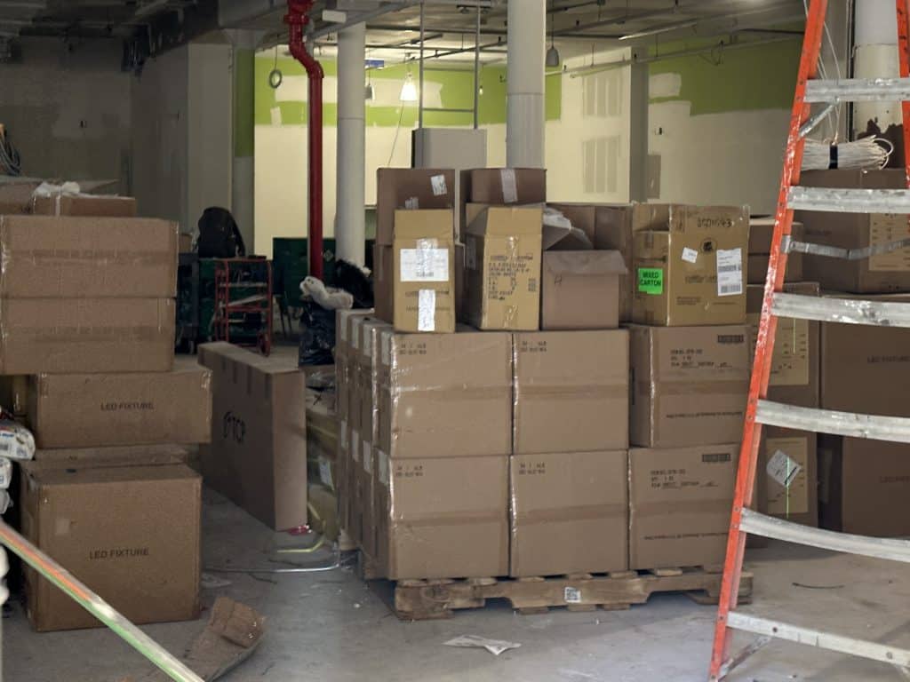 Construction materials are stacked up inside the raw retail space | Upper East Site