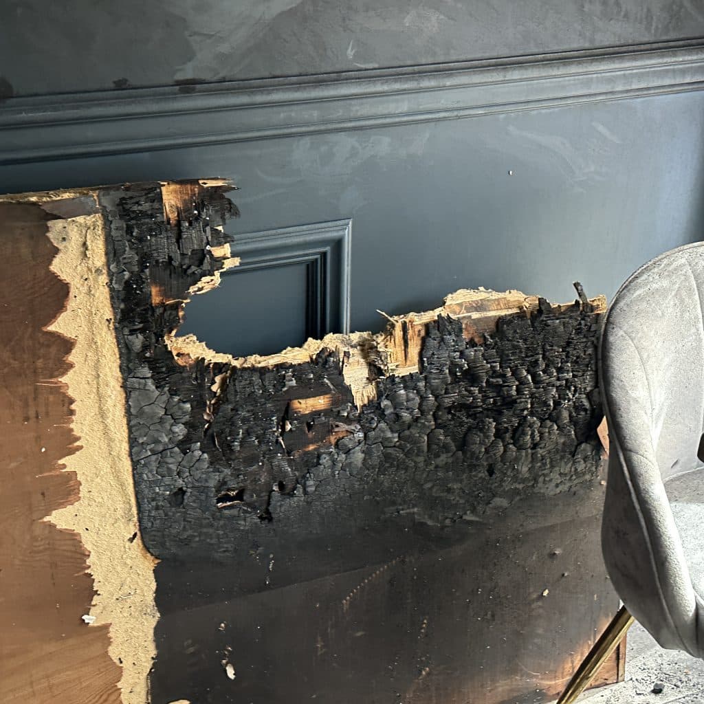 Flames destroyed this wood panel located where the outlet caught fire | Upper East Site