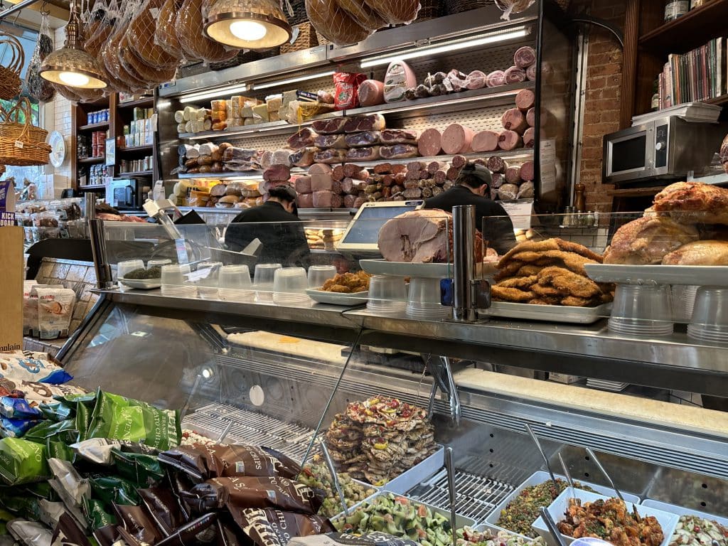 Milano Market prepares sandwiches behind the deli's display cases. Ready-to-eat foods are cooked in the basement kitchen | Upper East Site