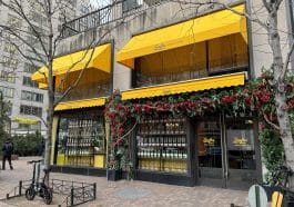 Photo shows the restaurant's exterior with double bright yellow awnings on the buildings first and second floors