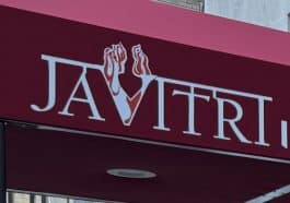 Photo shows a close up of a burgundy colored cloth awning with stylized text reading 'Javitri'