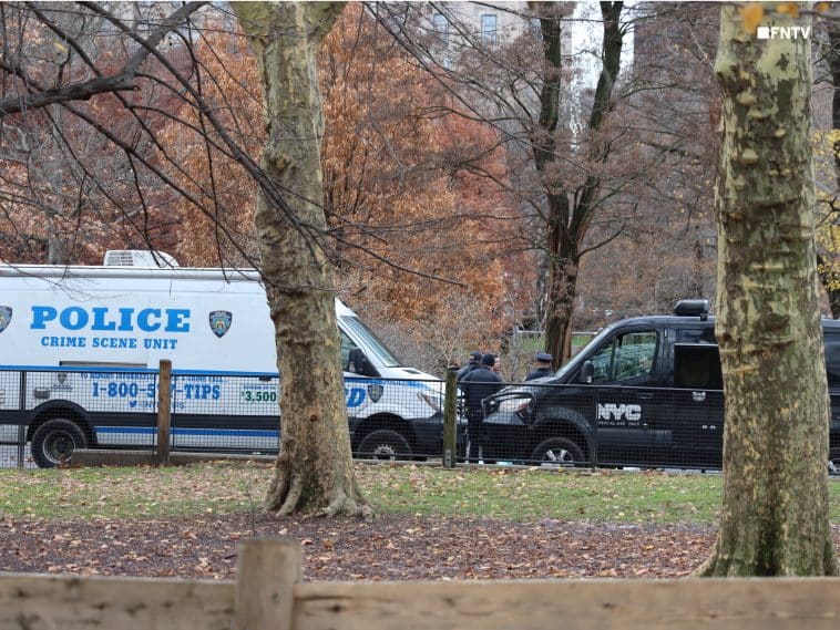Photo shows an NYPD Crime Scene Unit van and a black Medical Examiner's Office van parked within Central Park