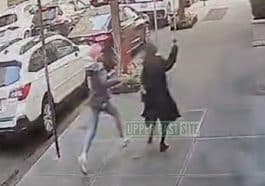 Blurry surveillance image shows a woman in a black top coat and tall boots running from a woman dressed in a grey hoodie and jeans.