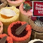 Composite shows an angled view of the the tops of colorful fancy cakes. Inset is a photo of a red sign with white lettering reading 'Avenue Bakery NYC.'