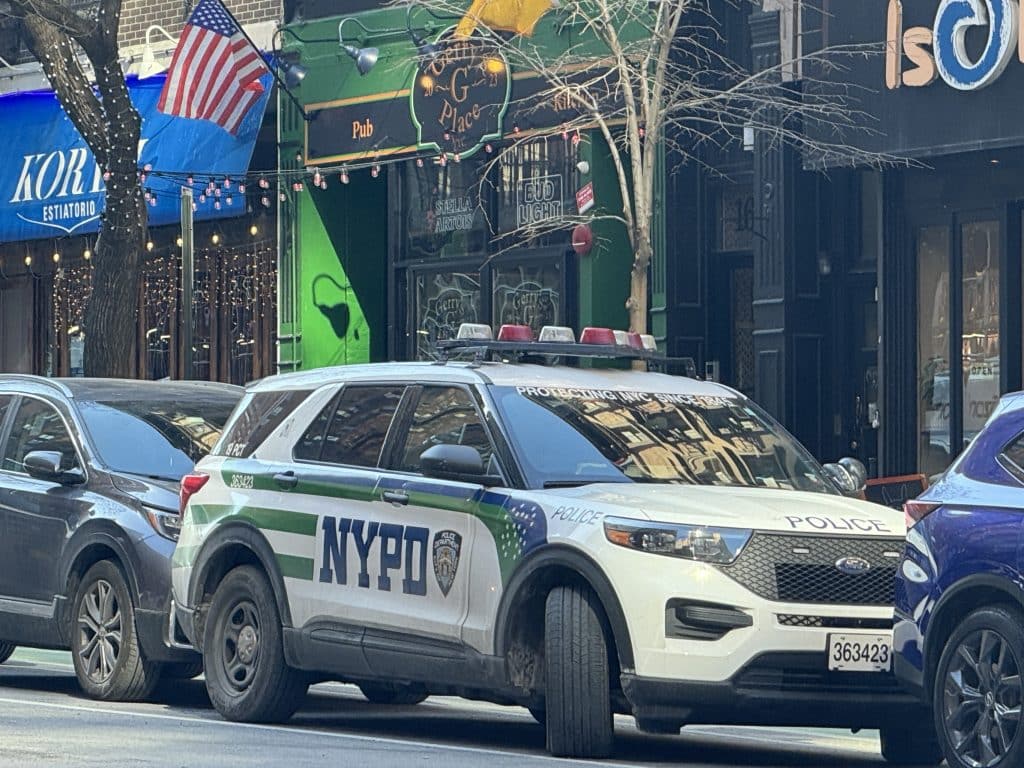 Photo shows an NYPD SUV parked in front of an Irish bar.