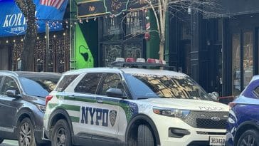 Photo shows an NYPD SUV parked in front of an Irish bar.