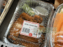 Photo shows a packages of hot wings in a refrigerated display case.