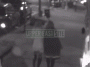 Gif is a clip of surveillance video showing a man on a moped attempting to steal a woman's purse at night.