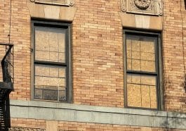 Photo shows two boarded up windows.