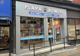 Photo shows a silver storefront with floor to ceiling windows and a sign reading 'PLAYA BOWLS.'