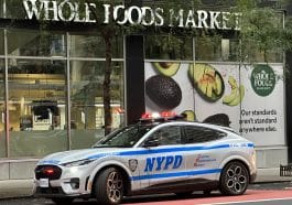 Photo shows a police car in front of Whole Foods Market.