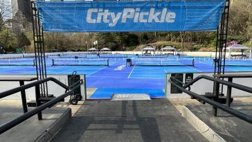 Photo shows the entrance to an ice rink whose ice is replaced with 14 pickleball courts.