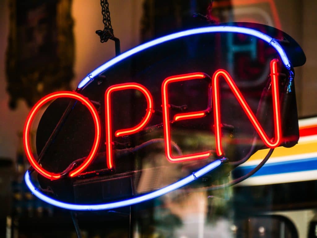 Photo shows a neon 'Open' sign.