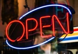 Photo shows a neon 'Open' sign.
